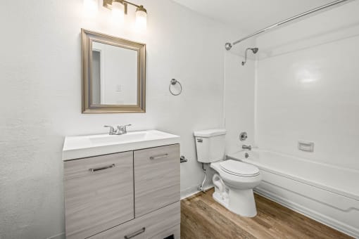 a bathroom with a white sink and toilet next to a white bathtub