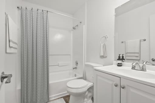 a white bathroom with a shower toilet and sink