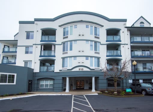 the apartment building has a parking lot in front of it