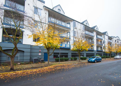 an apartment building with a blue car parked in front of it