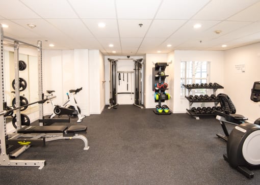 a gym with exercise equipment and weights on the floor