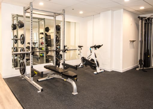 a gym with exercise equipment and weights on the floor