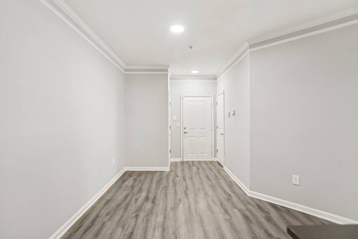 A room with a white door and a light on the ceiling.