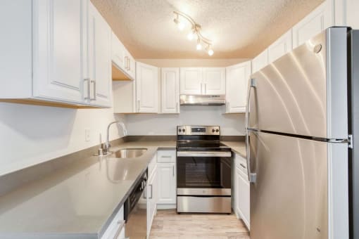 a kitchen with white cabinets and stainless steel appliances