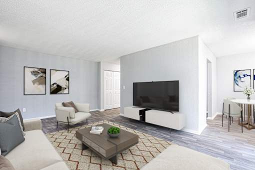 a living room with a large tv on the wall and a coffee table in the middle of