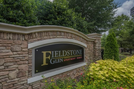 a stone wall with a sign for the fieldstone glen amphitheater park