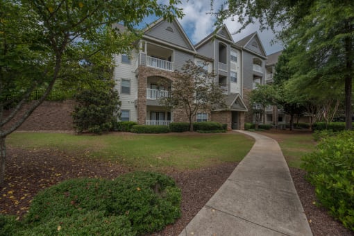 an apartment building with a sidewalk in front of it