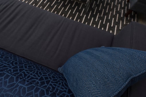 a dark blue couch with a blue pillow on it