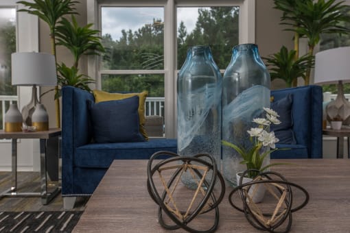 a living room with blue couches and a table with vases