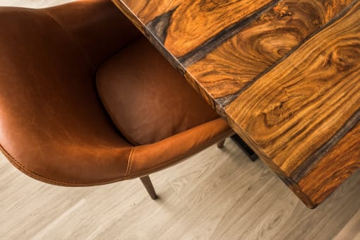a pair of brown leather chairs and a wooden table