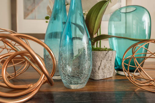 a group of glass vases sitting on top of a wooden table