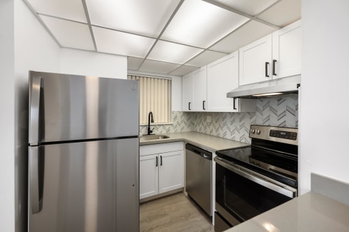 a kitchen with stainless steel appliances and white cabinets