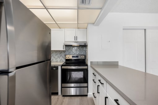 a kitchen with stainless steel appliances and white cabinets