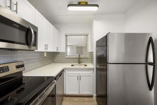 a kitchen with stainless steel appliances and white cabinets