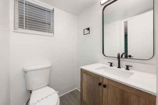 an empty bathroom with a toilet sink and mirror