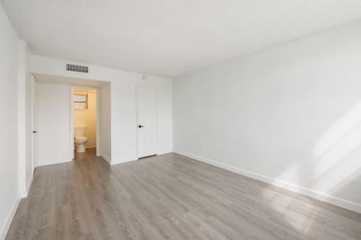 an empty living room with white walls and wood flooring