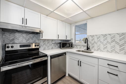 a kitchen with white cabinets and black appliances and a sink
