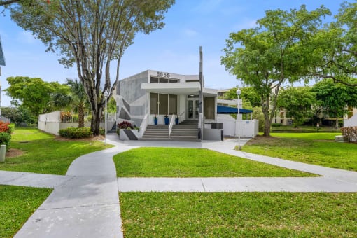 a house with a lawn and stairs in front of it