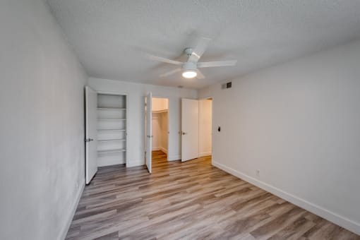 a bedroom with a ceiling fan and hardwood floors