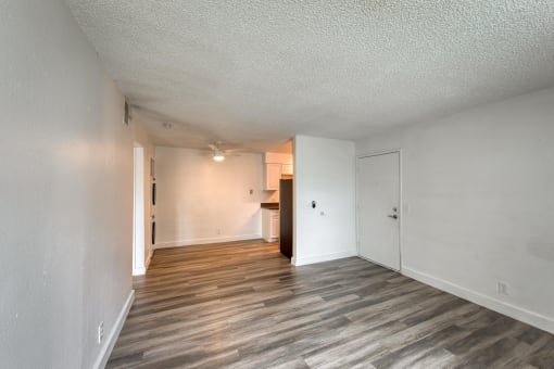 a bedroom with hardwood flooring and white walls