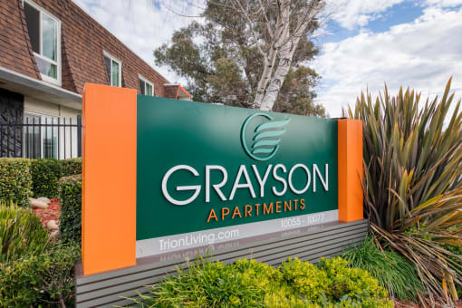 a sign with a green background and an orange background with the words grayson apartments