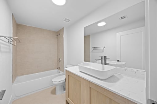 A modern bathroom with a white sink and a white toilet.