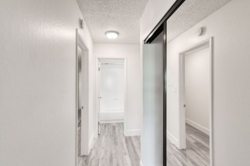 a bedroom with a large mirror and a hallway in the background