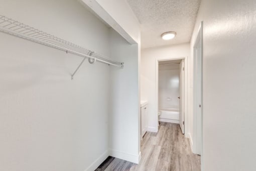 a bedroom with a medium sized closet and a bathroom in the background