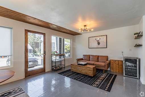 A living room with a brown couch and a fireplace.