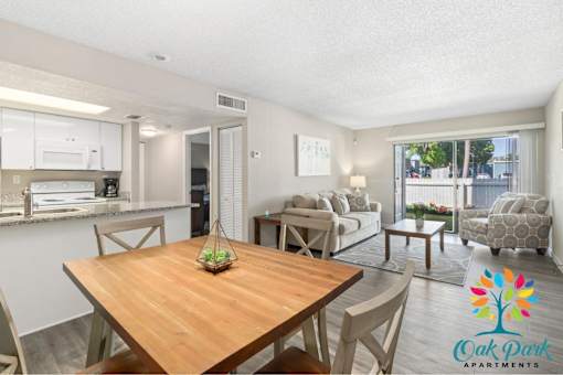 A well-lit apartment living room with a dining table and chairs.