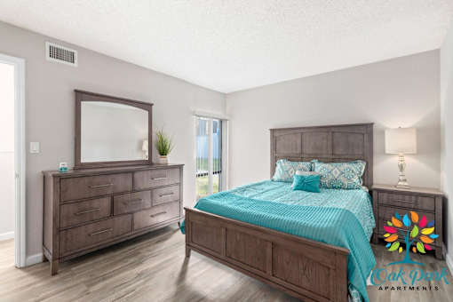 A bedroom with a bed, dresser, and mirror.