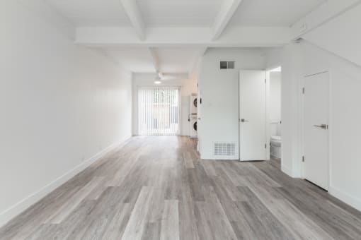 a bedroom with hardwood floors and white walls
