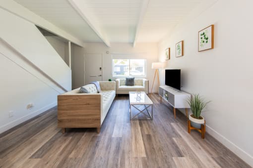 a living room with a white couch and a wooden coffee table