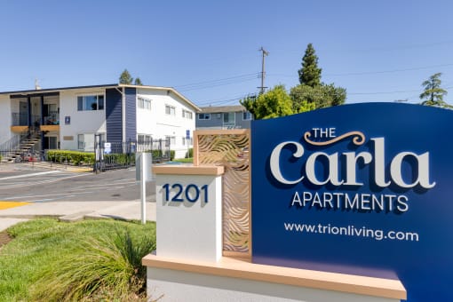 a sign that says the carla apartments with houses in the background
