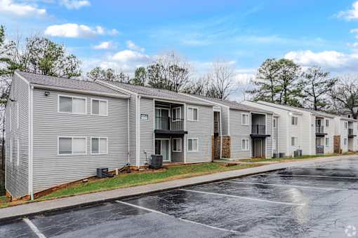 A row of townhouses with a parking lot in front.