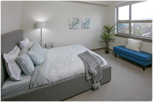 a bedroom with a large bed and a blue chaise lounge