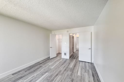 a bedroom with hardwood floors and white walls