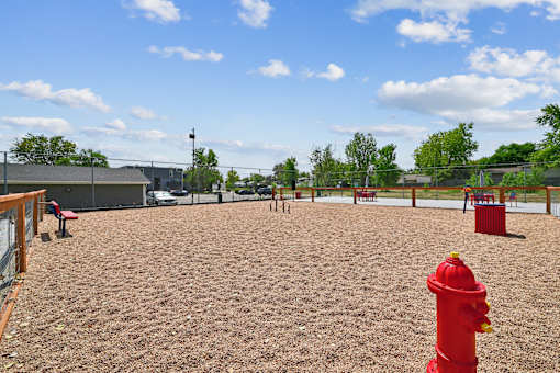 A red fire hydrant sits in the middle of a playground.