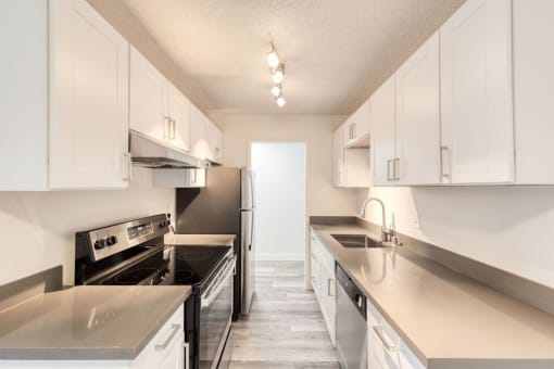 a kitchen with white cabinets and stainless steel appliances