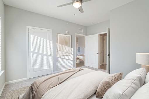 A room with a ceiling fan and two doors.