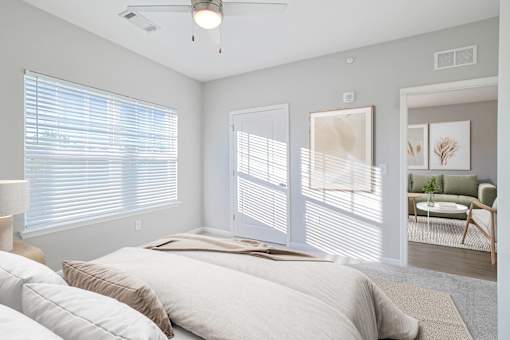 A room with a ceiling fan and a window with blinds.