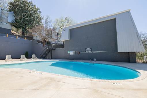 A swimming pool in front of a grey building.