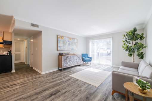 A living room with a grey sofa, a blue chair, and a wooden coffee table.