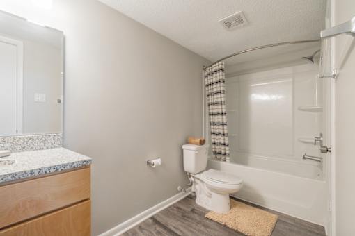A bathroom with a toilet, sink, and bathtub.