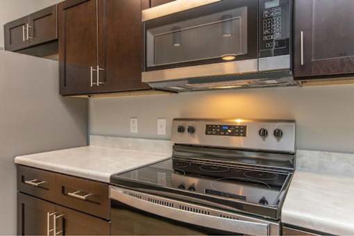 A modern kitchen with a stove top oven and microwave above it.