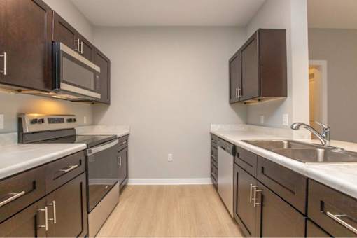 A kitchen with brown cabinets and a white counter top.