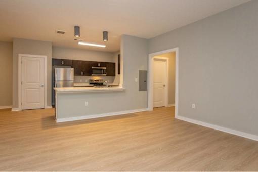 A kitchen with a refrigerator, microwave, and oven is shown.