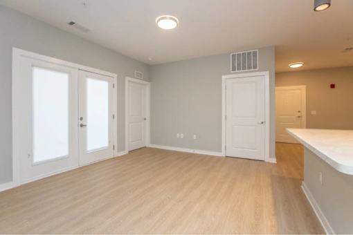 A room with white doors and a window, and a white counter.