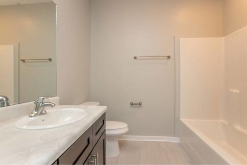 A white sink is on a countertop in a bathroom.