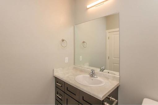 A bathroom with a sink, mirror, and toilet.